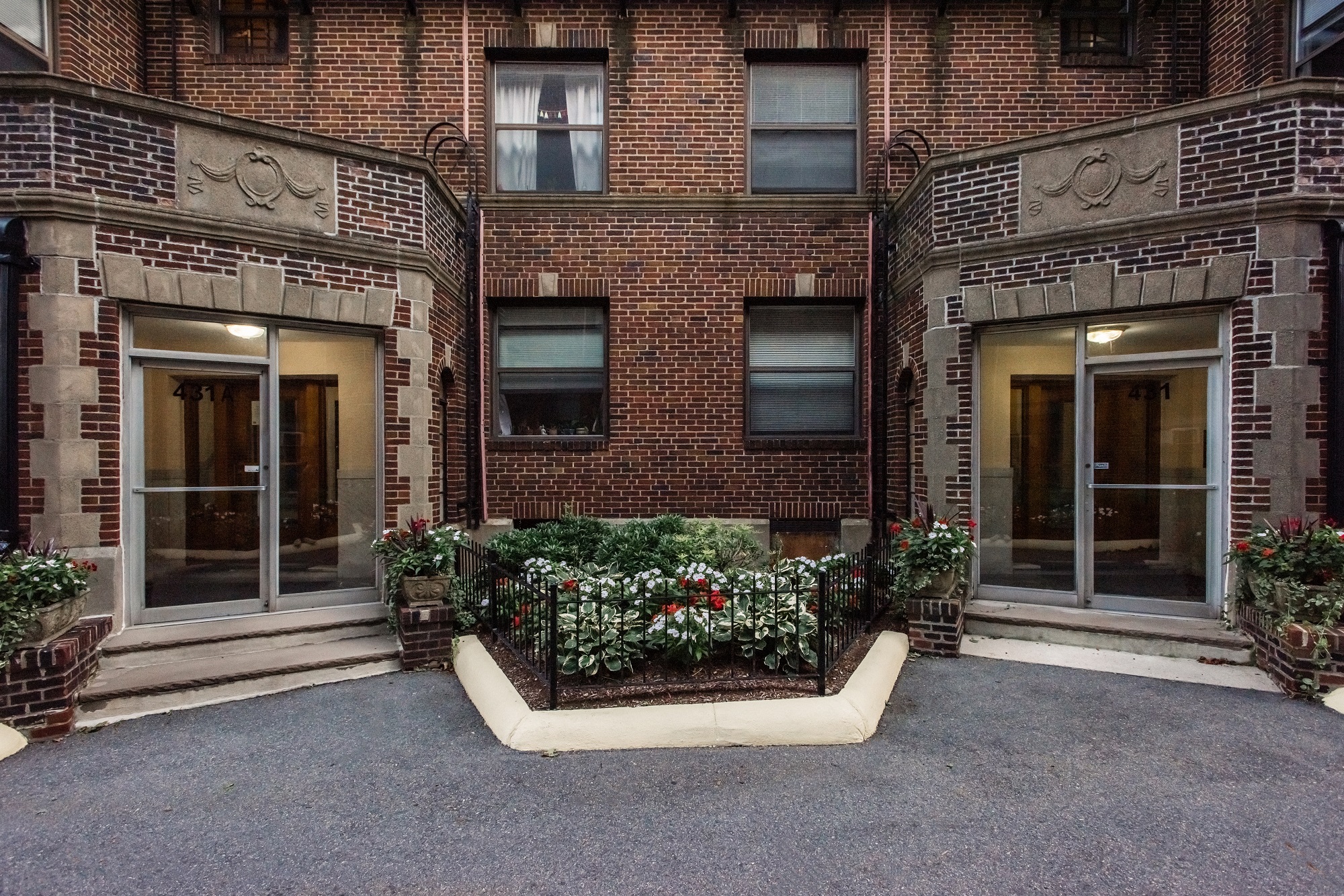 the front of a brick apartment building with a courtyard